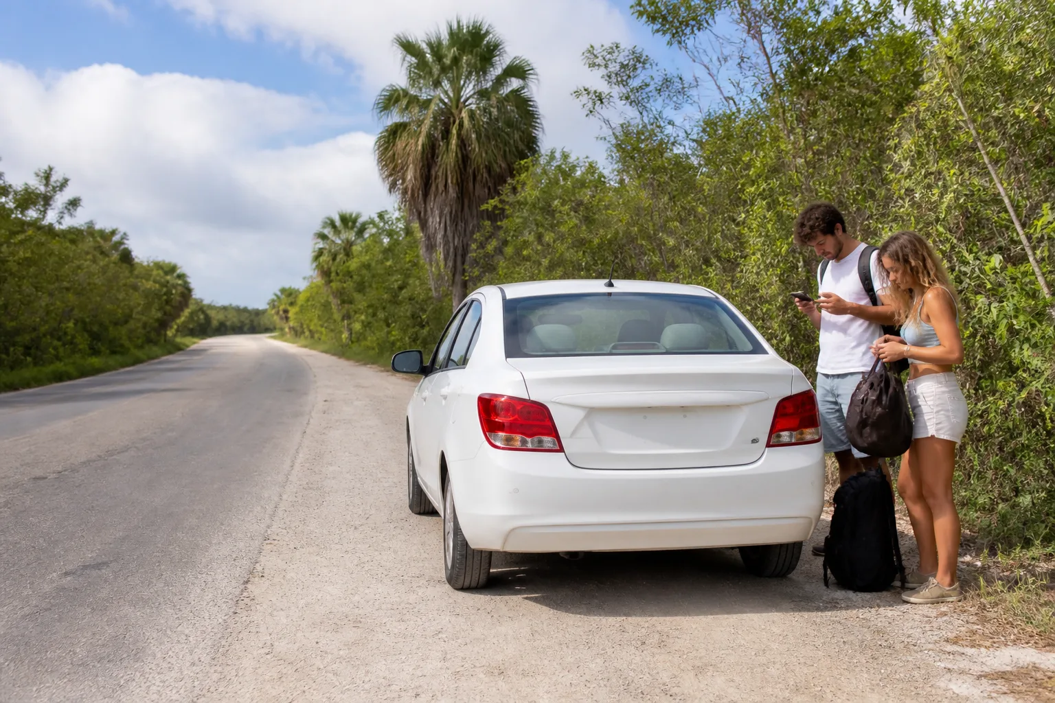Travelers preparing for a return pickup on a tropical road near Tulum