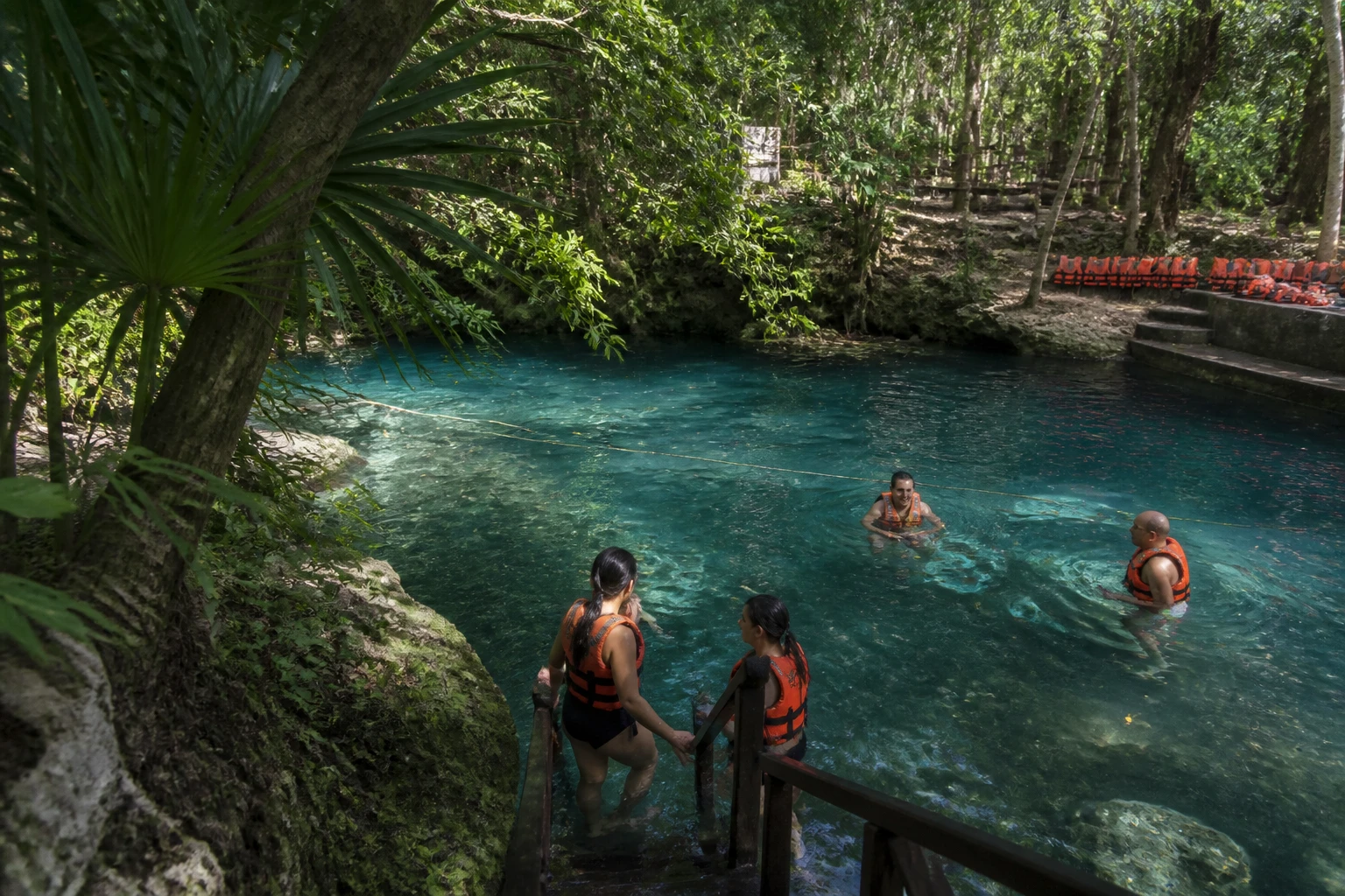 Travelers preparing to enter freshwater safely during a Tulum tour