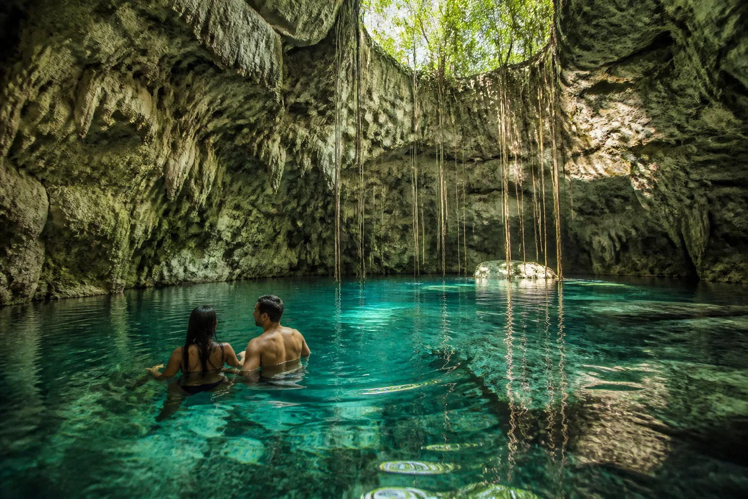 Couple swimming together in a cenote near Tulum