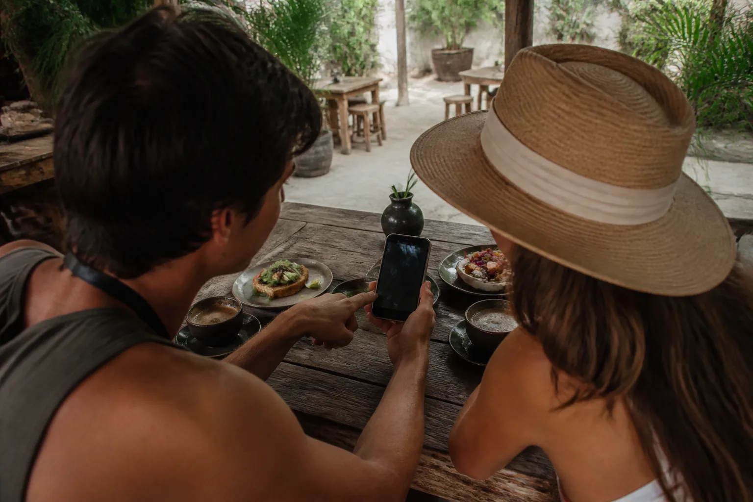 Travelers checking their plans at a café in Tulum
