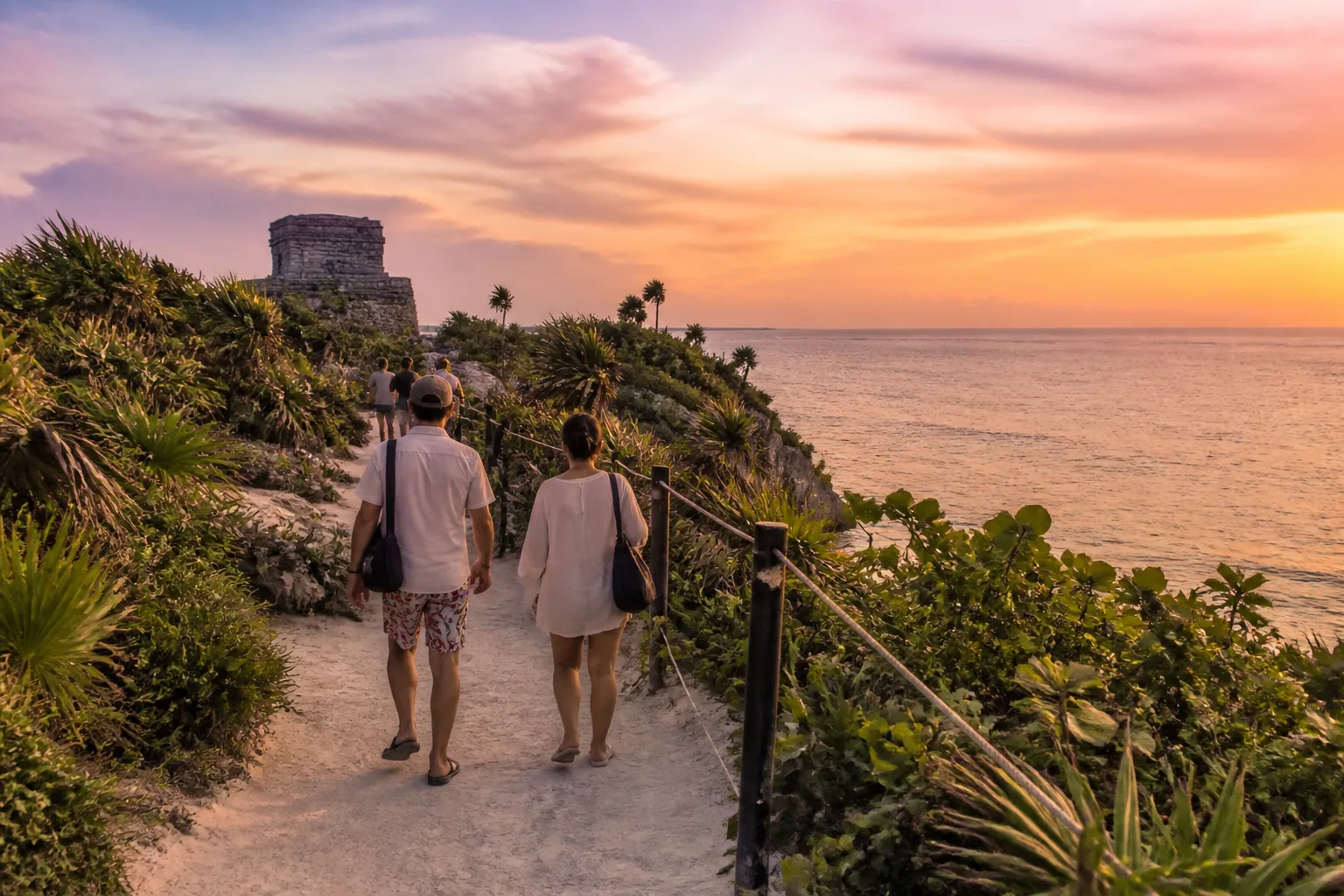 Visitors leaving a Tulum beach in evening light